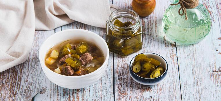 Delicious cabbage soup with beef and jalapenos in a bowl on the table web banner photo