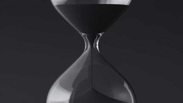 Hourglass With Black Sand Falling in Time on a Dark Background in Studio photo