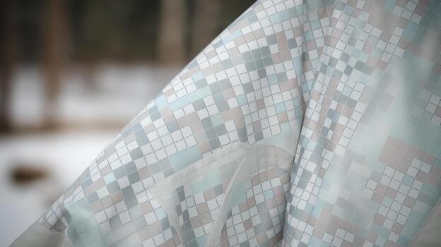 Close up of a Winter Jacket With a Square Mosaic Pattern in a Snowy Forest Environment photo