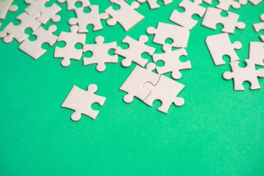 Scattered Puzzle Pieces on a Green Background Symbolizing Problem Solving and Strategy photo