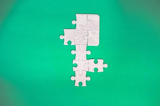 Conceptual Image of a Jigsaw Puzzle Partially Assembled on a Green Background photo