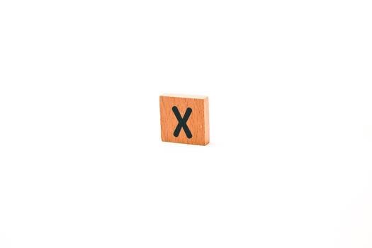 Isolated wooden block with letter X on white background for educational use or design element, creating a clean studio shot photo