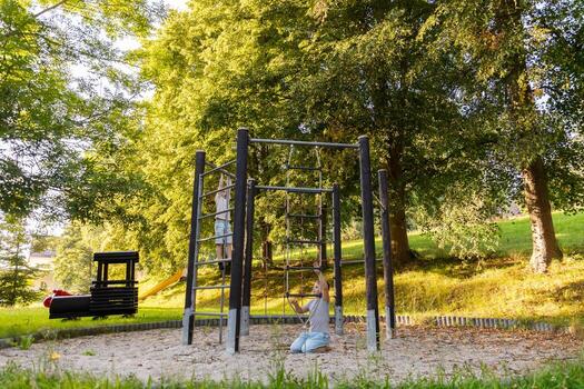 dos niños son teniendo divertido alpinismo en un patio de recreo estructura en un verde parque. ellos son riendo y jugando mientras rodeado por alto arboles en un brillante tarde foto
