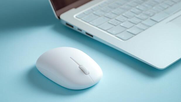 Light blue surface with white wireless mouse and laptop photo
