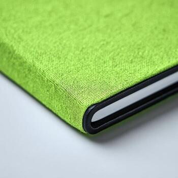 Close-up of a vibrant lime green notebook cover with black edges photo