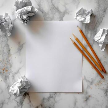 Blank paper with crumpled paper balls and pencils on marble photo