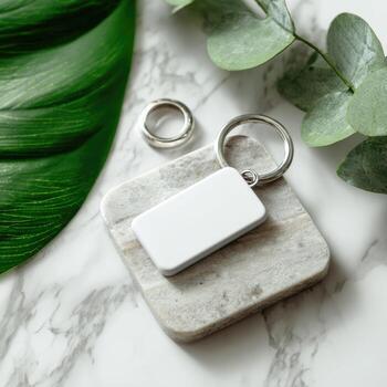 Blank rectangular key tag on marble coaster, surrounded by greenery photo