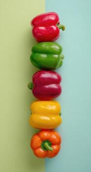 Colorful peppers in a vertical line against a pastel background photo