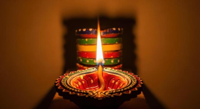 A colorful diya lit up on a table photo