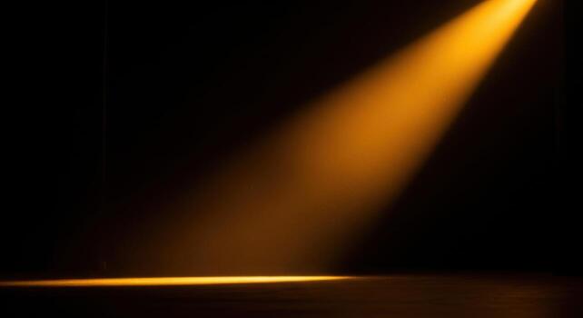 A spotlight shines on a dark stage photo