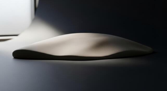 A white object sitting on a table in front of a window photo