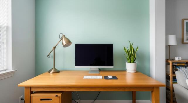 A desk with a computer, lamp and plant on it photo