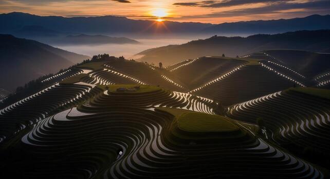 Golden sunset over ancient terraced rice fields with misty mountains and reflective water patterns photo