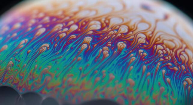 Macro close up of iridescent soap bubble surface with vibrant swirling colors and abstract patterns photo
