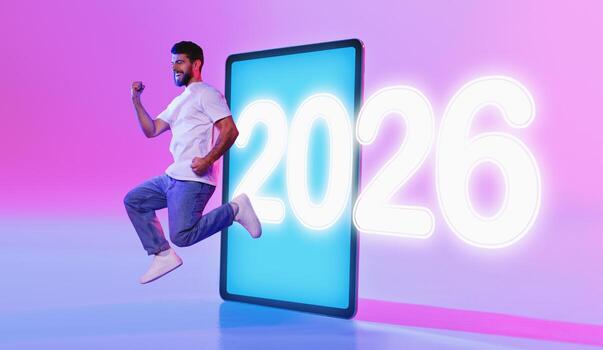 A modern tablet pc displays an empty white screen, illuminated by colorful neon lights. A man joyfully leaps beside it, representing innovation and creativity in app design. photo