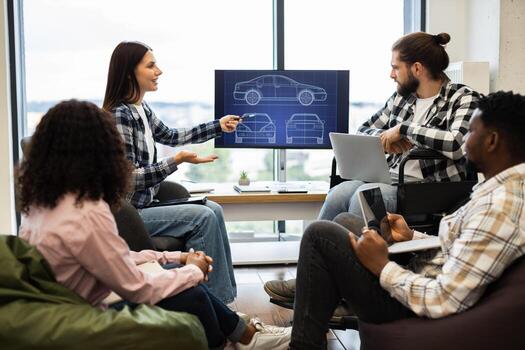 Engineers and designers brainstorming for new car design development using digital screen. Group of multicultural young adults engaged in collaborative teamwork session. photo