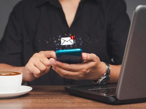 Business people using a mobile receive a new message with email icons while sitting at the table. photo