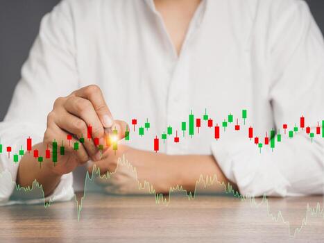 Close-up of a a businessman or trader pointing to a graph stock on a virtual screen photo