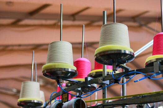 Spools of thread are in a spinning production line in the factory photo