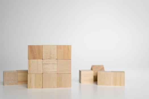 Wooden cubes arranged in solid square block on white background symbolizing structure, stability, order photo
