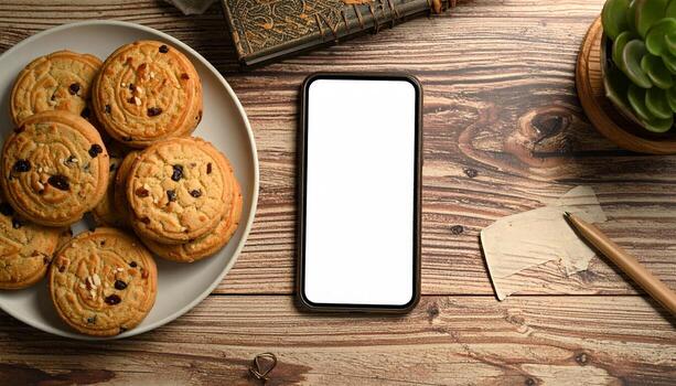 Cozy Workspace with Cookies and Smartphone Mockup. photo