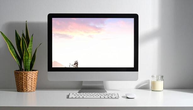 Minimalist Workspace with Computer Plant and Candle on White Desk. photo