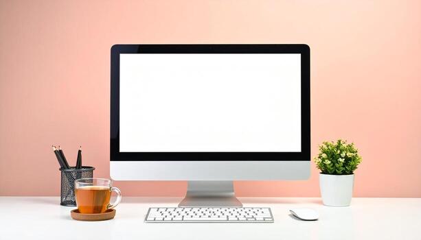Modern workspace setup with computer tea and plant on white desk. photo