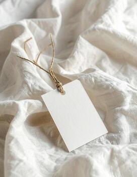 Blank tag on crumpled white fabric minimalist product display. photo