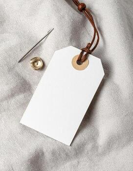 Blank white tag with string on textured fabric background photo