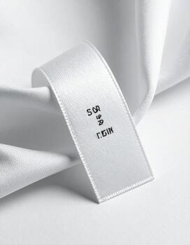 Closeup of a white fabric label with black text. photo