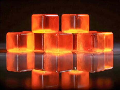 Glowing orange translucent cubes stacked in a pyramid shape reflecting on a glossy surface against a dark background creating a warm and vibrant ambiance photo