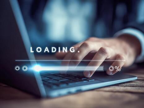 Close-up of a business persons hand typing on a laptop keyboard with a digital loading progress bar overlay in a dimly lit office environment photo