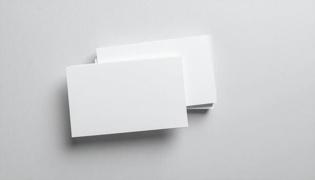 Stack of blank business cards resting on a gray surface, providing a clean and minimalist presentation for branding or contact information, conveying professionalism and simplicity. photo