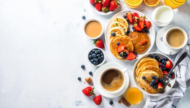 Delicious pancakes with fresh berries and coffee are arranged on a white table for a bright and cheerful breakfast, creating a cozy and inviting scene. photo