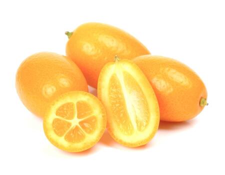Kumquats are arranged on a white surface, with one sliced in half and another cut into a round shape, showcasing their vibrant orange color and juicy texture, creating a fresh and appealing image. photo