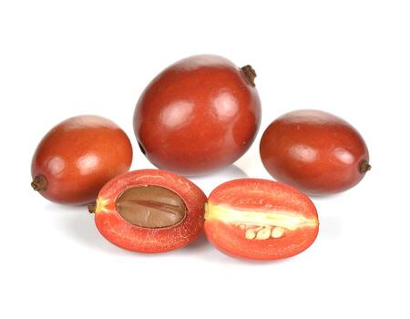 Fresh miracle fruit arranged on white surface showcases vibrant color and unique texture, creating clean and inviting still life composition. photo