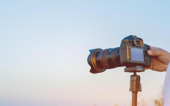 Camera mounted on a tripod, working of professional photographers and tourists taking photos. photo