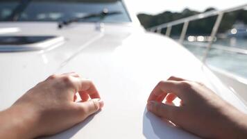 Hands rhythmically tapping on the pristine white surface of a yacht,creating visual music video