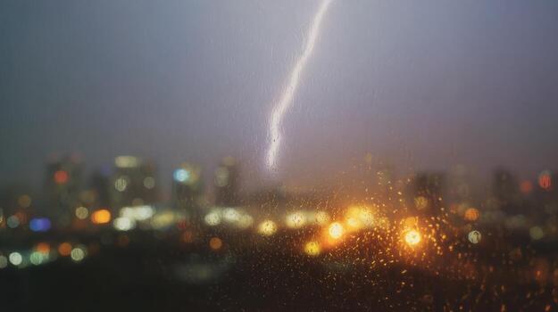 Lightning Strike Over Cityscape Through Rain-Soaked Window. Capturing The Power Of Nature Amidst Urban Lights photo