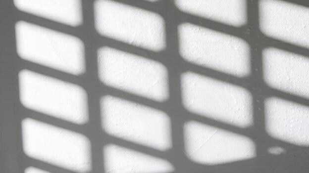 Light and Shadow Pattern on a White Wall Creating Abstract Shapes photo