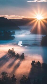 Sunrise Over Foggy Valley With River and Trees Casting Long Shadows in the Early Morning photo