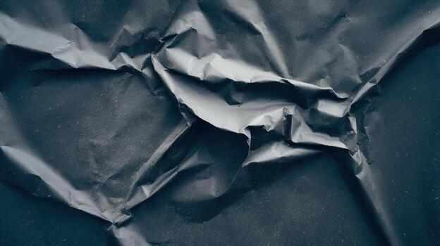 Crumpled Dark Paper Shows Unique Texture and Shadow Patterns photo