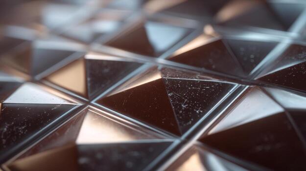 Abstract close-up of a shiny, geometric surface featuring triangular metallic patterns and soft reflections. photo