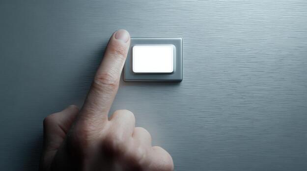 A close-up of a person's finger pressing a sleek, modern light switch on a brushed metal wall. photo