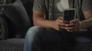 uomo seduta su divano soffre cuore attacco mentre utilizzando smartphone video