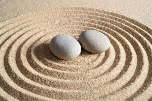 dos piedras en un arena circulo con un espiral modelo foto