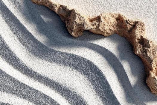 texturizado arenoso superficie con amable olas y un escabroso rock formación, creando un armonioso mezcla de natural elementos y patrones en un sereno ambiente foto