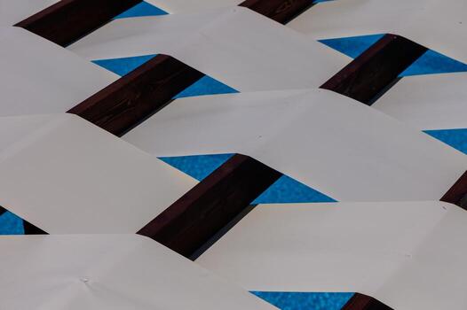 Abstract composition of white stripe shadows over wooden planks. Light and texture create a minimal summer pattern, suitable for design and backgrounds. photo