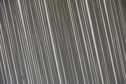 Soft shadow from a thatched reed roof falls on a white wall, creating a natural abstract pattern. photo