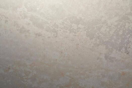 Smooth, textured surface of light gray stone with subtle variations in color and pattern visible under soft light conditions photo